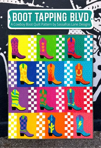 Fertig genähter Patchwork-Quilt mit 16 bunten Cowboystiefel-Applikationen auf Karomuster-Hintergrund, in vier Reihen an einer Wand präsentiert.
